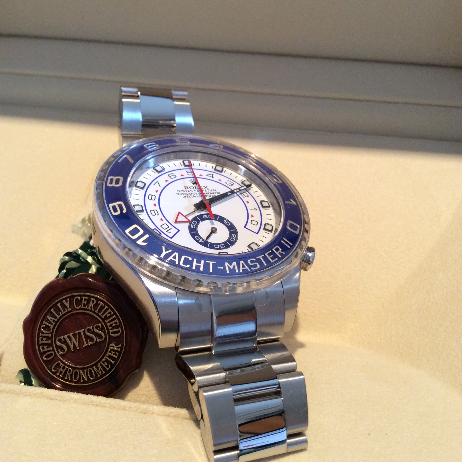 Photograph of a stainless steel Rolex Yacht-Master II reference 116680 regatta chronograph with a blue ceramic Ring Command countdown bezel in its presentation box